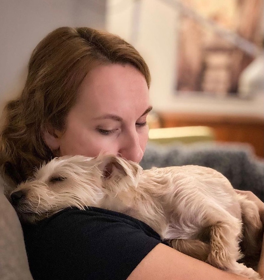 Woman holding dog who doesn't feel well.